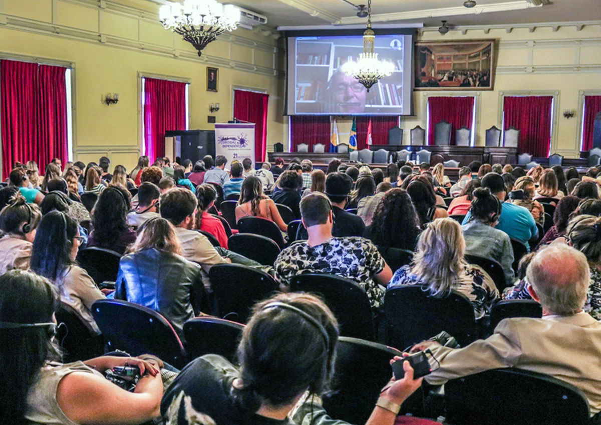 Auditório durante um encontro sobre adições, com Bruce K. Alexander em videoconferência